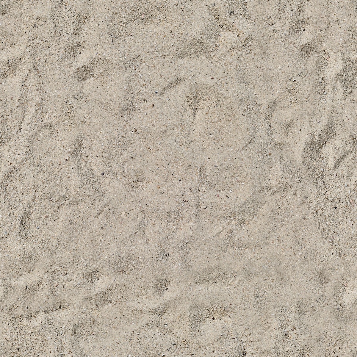 natural light beige sand surface with fine grains and small pebbles showing footprints and irregular patterns