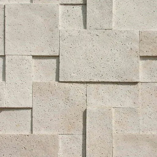 Light beige limestone blocks with a rough, porous surface arranged in a wall pattern, suitable for architectural cladding.